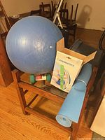 Lot overview showing blue exercise ball, green dumbbell, blue yoga mat, Energetics box