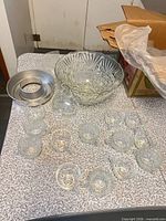 Punch bowl, ice pan and twelve cups on table