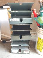 Full stack of green metal filing trays showing quantity and overall wear