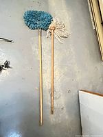 Full view of both wooden-handled mops on floor