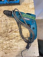 Full view of Makita corded drill with cord coiled