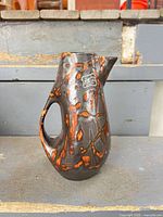 Full view of pitcher showing shape, handle and lava glaze pattern