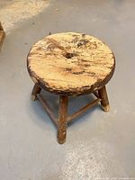 Top view of round wooden stool showing distressed surface