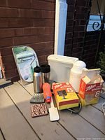 Group shot of all items on porch including carafe, water bottles, travel mug, squeeze bottle, Zellers boxes, storage bin