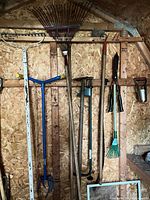 Overall view of hanging garden tools on shed wall