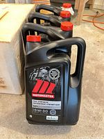 Three Motomaster 5 L motor oil jugs upright