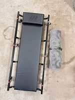 Top view of MotoMaster black creeper and grey rolled knee pad
