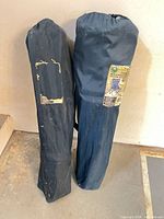 Two blue carry bags standing upright