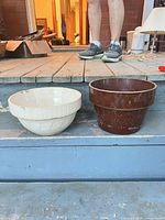 Brown crock and cream bowl side by side on steps