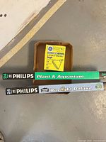 Two Philips fluorescent tube boxes and one GE halogen bulb box in tray