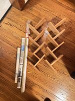 Pine CD rack and three rolled posters on hardwood floor