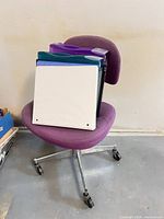 Front view showing purple fabric chair with metal base and casters