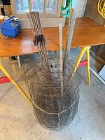Full view of rolled wire fencing with stakes inside