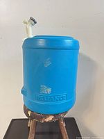 Front view of blue Reliance 5-gallon water jug showing body, color, general wear
