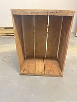 Front view of apple crate showing open slat construction and wood texture