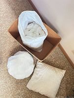 Top view of box containing bag of fiberfill and two pillows