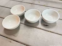 Four small white bowls displayed top view