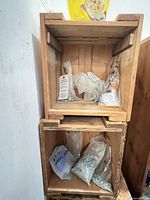 Three wooden crates stacked with bags of hardware inside