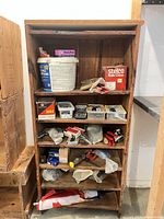 Full view of tall wood bookcase with contents on shelves