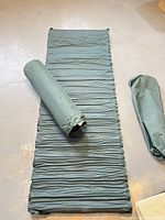 Full-length view of one pad unrolled with another rolled pad and stuff sack visible