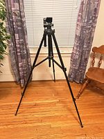 Tripod fully extended on hardwood floor showing overall structure