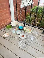 overview of all dinnerware, glassware and figurines on porch floor