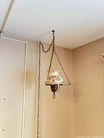 Full view of hanging pendant lamp with chains and shade