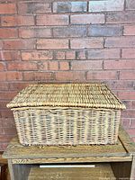 Closed rectangular wicker basket on wooden surface