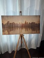 Front view of signed city skyline canvas on easel