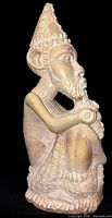 Full side view of carved wooden tribal figure