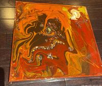 Front view of square abstract painting showing colors and embellishments