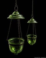Both green glass hanging planters suspended, showing size difference, chains and domed tops