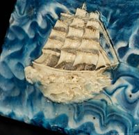 close-up of tall ship relief on marbled stone lid