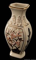 Angled view showing cherry blossom panel, gold trim and faceted silhouette