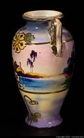 Three-quarter view of vase showing landscape scene, floral enamel and one gilt handle