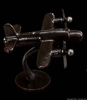 Angled top view of welded steel twin-prop airplane sculpture on stand