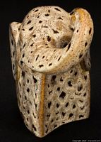 Rear three-quarter view of ceramic elephant showing raised trunk and speckled glaze pattern