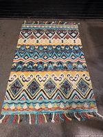 Full view of rug showing pattern, colors and fringe