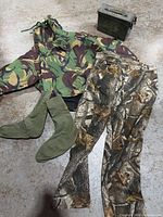 Group shot of smock, hunting pants, socks and ammunition can