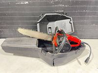 Chainsaw in opened cracked plastic case