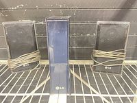 Front view of three LG speakers on shelf