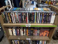 Full cart showing two shelves of DVD cases, approx 80 items