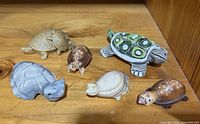Six turtle figurines displayed on wooden surface