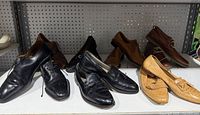 Shelf with multiple pairs of black and brown men’s leather shoes, various styles