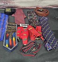 All 9 items laid out: 4 ties, 3 suspenders, 2 belts
