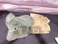 Olive fleece jacket, tan thermal bottoms, olive beanie displayed together