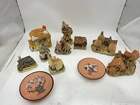 Group view of nine miniature houses and two floral plaques