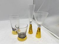 All four clear glass cocktail glasses with hammered gold bases