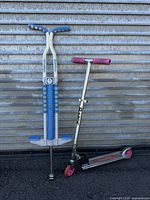 Both Razor scooter and Master pogo stick leaning against metal wall