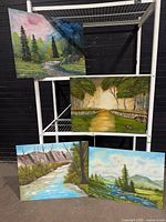 All four unframed acrylic landscape paintings displayed on shelving